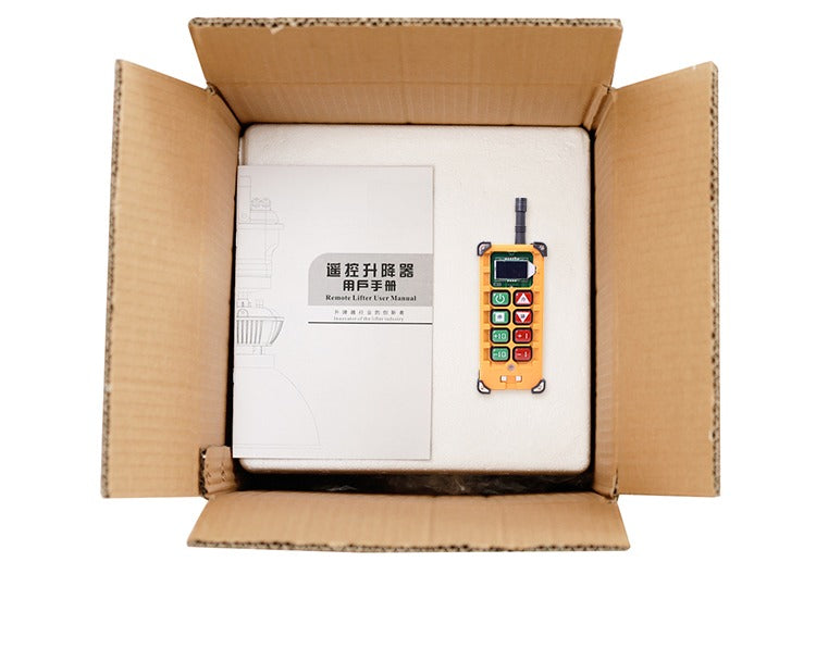 High bay lamp lift remote control and manual inside an open cardboard box.